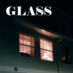 The title "Glass" with a shattered "S" over a window illuminated in the night.